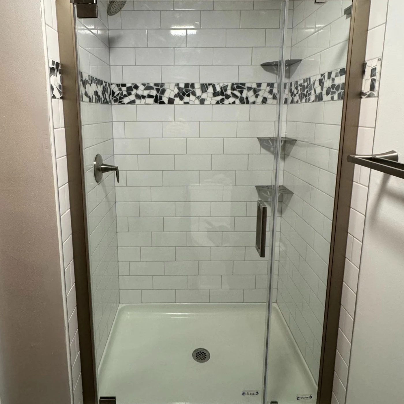 Cooper Home Improvements shower with white subway tile, a dark mosaic accent and a glass enclosure